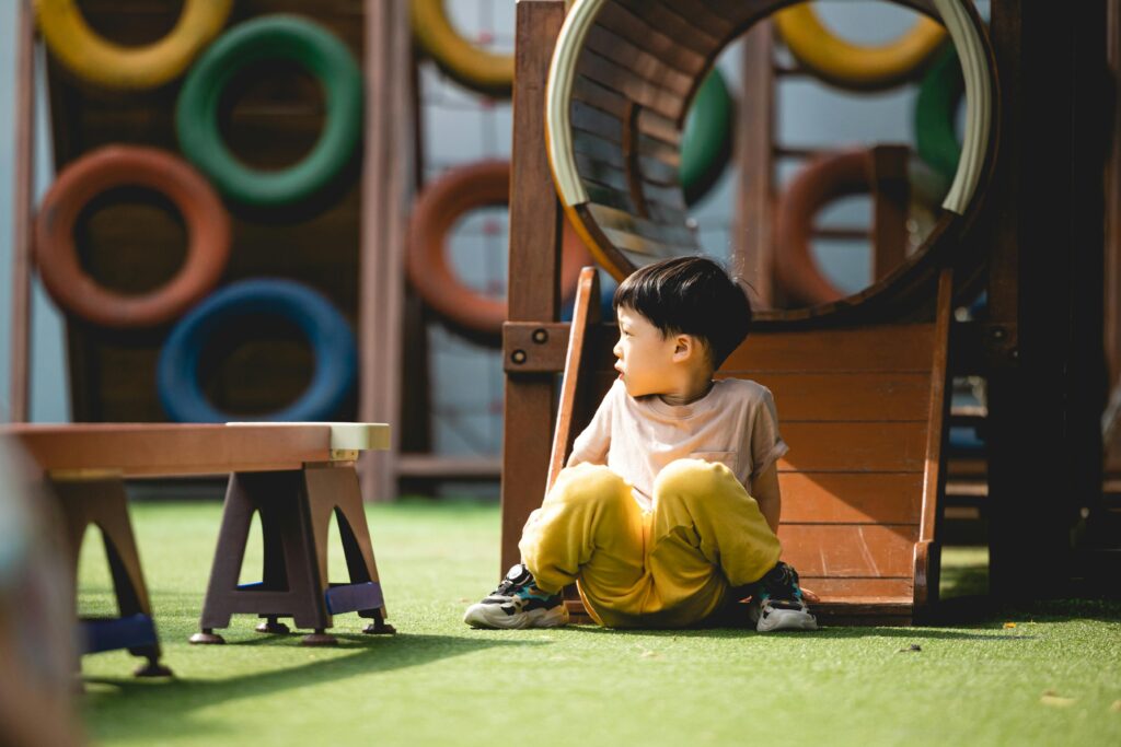 pexels-photo-18830101-18830101 A young boy plays on colorful playground equipment during a sunny day.